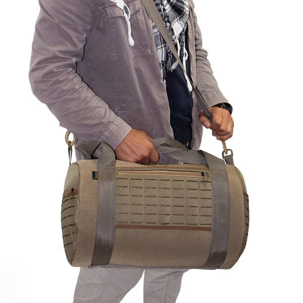 Homem segurando bolsa de viagem marrom.