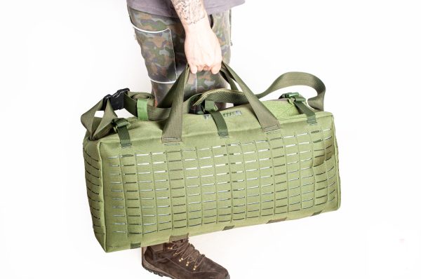 Persona carregando grande bolsa verde militar.