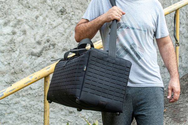 Homem carregando bolsa preta com alça.